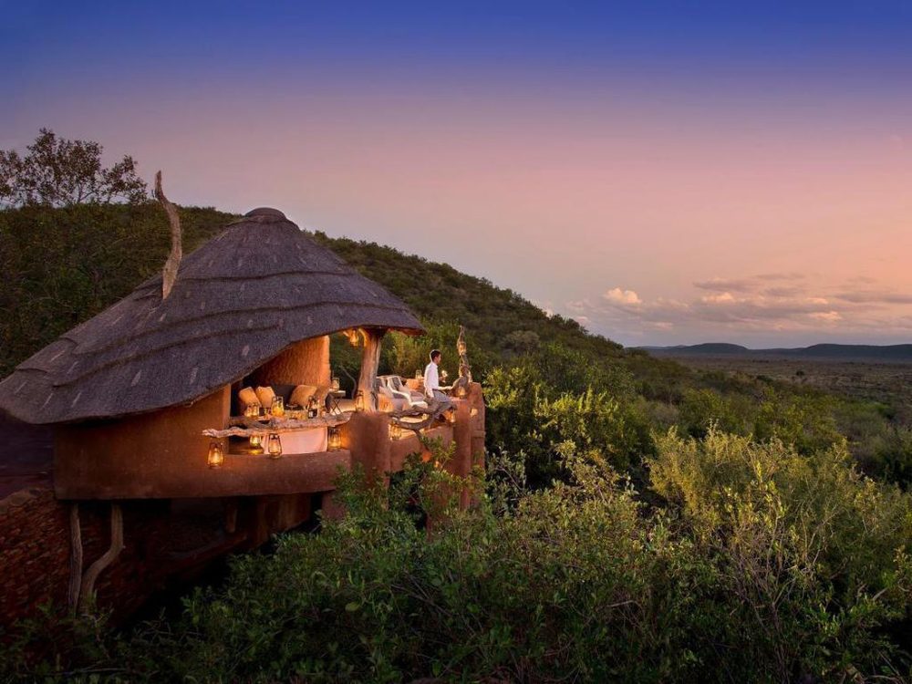 Thatched safari lodge dining deck at dusk overlooking the bush